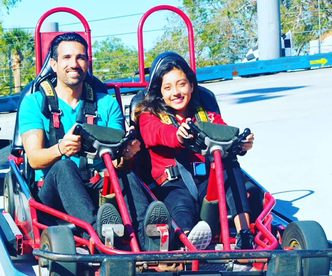 Smiling couple driving a tandem go-kart